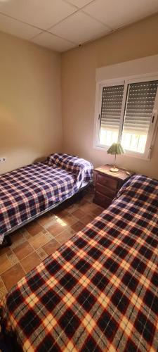 sypialnia z 2 łóżkami i stołem oraz 2 oknami w obiekcie La Casa del Rio w mieście Casabermeja
