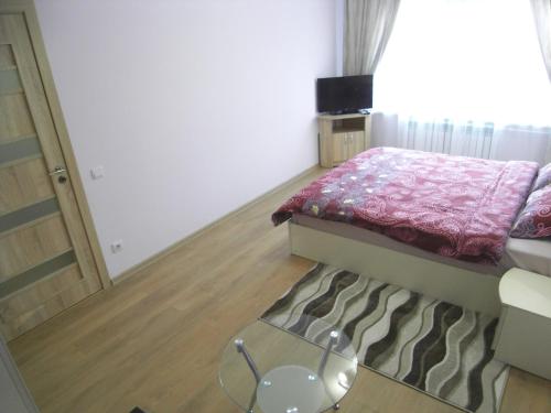 a small bedroom with a bed and a glass table at Modern Apartment in Chişinău