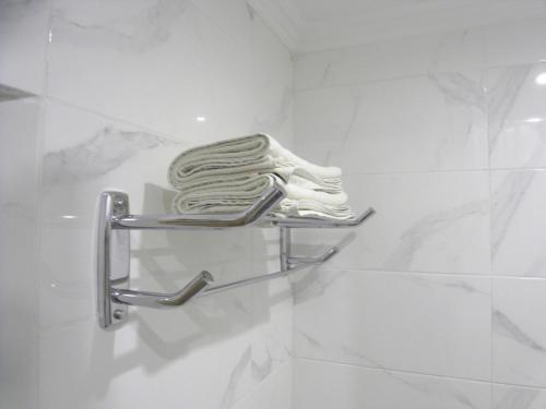 a towel rack in a bathroom with white marble at Modern Apartment in Chişinău