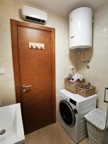 a kitchen with a washing machine and a brown door at Charming and Luxurious Flat with Large Terrace in Herceg-Novi