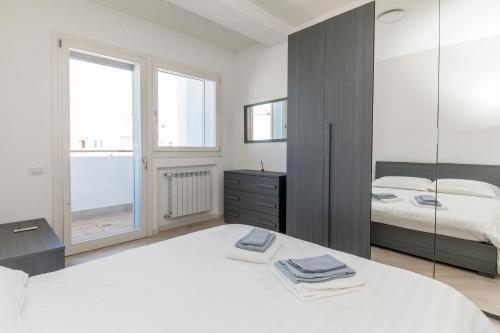 Habitación blanca con 2 camas y espejo. en 12° Piano Torre Diamante - 67, en Milán