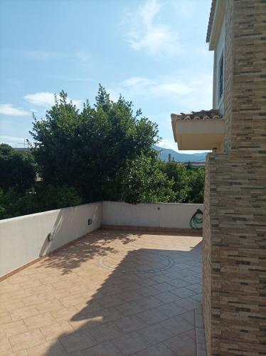 a patio outside of a house with a wall at Aegean Sea Home in Nea Makri