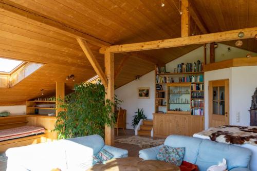a living room with a wooden ceiling and a bed at Ferienwohnung mit großem Panoramafenster in Teisendorf