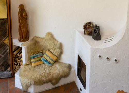 a furry chair with pillows on it in a room at Ferienwohnung mit großem Panoramafenster in Teisendorf