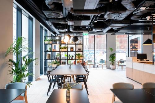 een eetkamer met tafels, stoelen en planten bij Staycity Aparthotels Dublin City Quay in Dublin