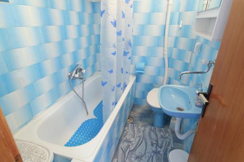 Baño azul con aseo, bañera y lavamanos en Old Fashion Guest House en Soko Banja