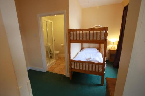 a bedroom with a bunk bed and a bathroom at Inn at Ardgour in Onich