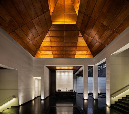 a lobby of a building with a wooden ceiling at Paresa Resort Phuket in Kamala Beach