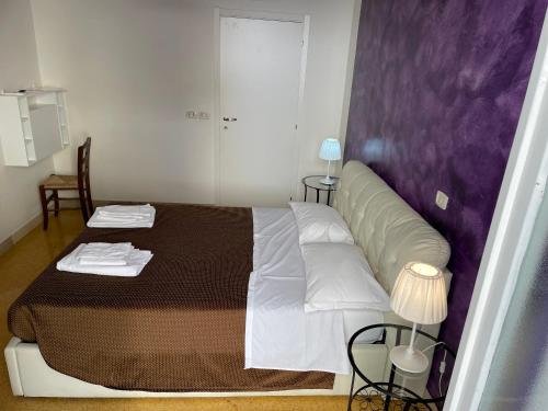 a bedroom with a large bed with a purple headboard at B&B Antichi Riverberi in Station in Salerno