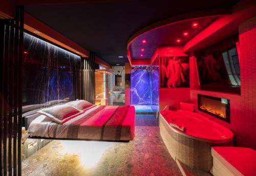 Dormitorio rojo con cama, lavabo y bañera en Garda fantasy green jacuzzi sauna piscina, en Desenzano del Garda