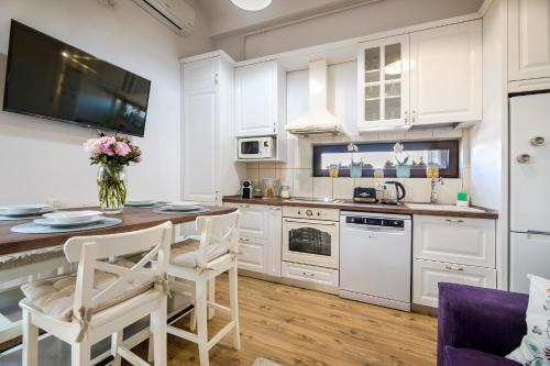 a kitchen with white cabinets and a table and chairs at Bucharest Penthouse with Sauna and Terrace in Bucharest