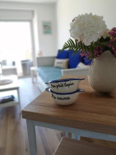 un vase de fleurs assis au-dessus d'une table dans l'établissement L'Échappée Bleue, vue mer, à Binic