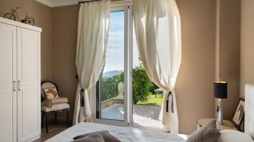 a bedroom with a bed and a sliding glass door at Villa Dolphin 10, Emma Villas in Massarosa