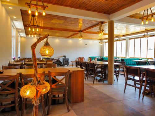 Kanyon park otel ve restaurant في ديميرجي: غرفة طعام مع طاولات وكراسي خشبية
