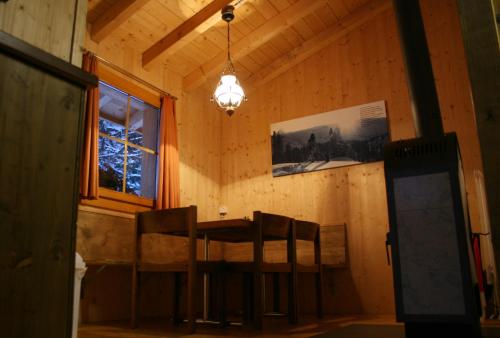a dining room with a table and chairs and a window at Hüttenhotel Husky Lodge in Muotathal