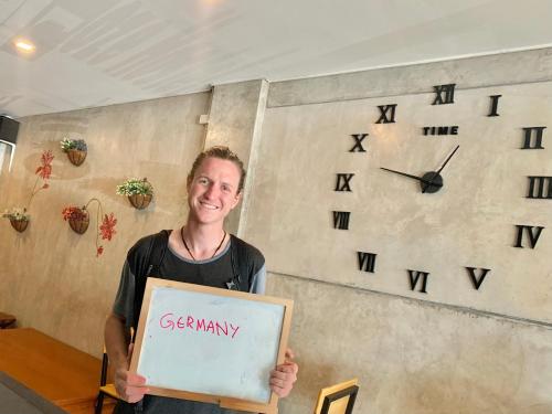 a man holding a sign with the word geometry at Doze Hostel in Chiang Mai