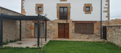 a building with a door and a grass yard at Casa del Medio in Fuentecantos