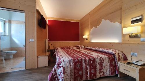 a bedroom with a large bed and a bathroom at La Montanina Hotel in Val di Non in Malosco