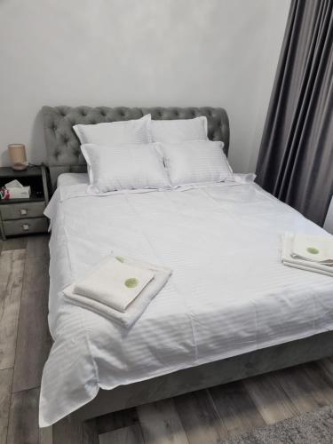 a bed with white sheets and towels on it at Anto1 in Călăraşi