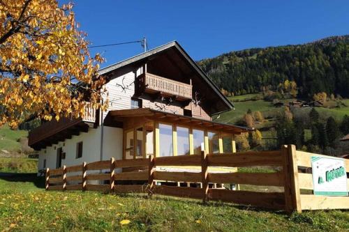 ein Haus mit einem Zaun davor in der Unterkunft Chalet in Grosskirchheim in Carinthia with sauna in Großkirchheim