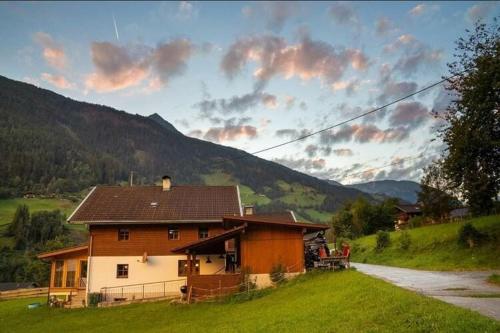 a house in a grassy field with a mountain at Chalet in Grosskirchheim in Carinthia with sauna in Großkirchheim