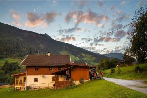 una casa en un campo de hierba con una montaña en Chalet in Grosskirchheim in Carinthia with sauna, en Großkirchheim