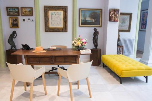 um quarto com uma secretária e um banco amarelo em Hotel Oleum - Parking Gratuito Reserva Previa em Andújar