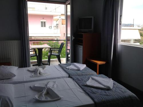 een hotelkamer met twee bedden met servetten erop bij Morfeas Hotel in Chalkida