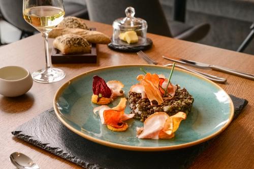 a plate of food on a table with a glass of wine at Mercure Geneva Airport in Geneva