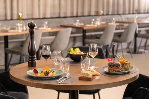 a table with plates of food and glasses of wine at Mercure Geneva Airport in Geneva