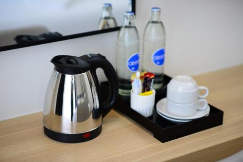 a black and silver tea kettle and drinks on a counter at Grand BS Airport Hotel Suvarnabhumi in Lat Krabang