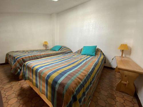 - une chambre avec 2 lits dotés d'oreillers bleus dans l'établissement Charmant pavillon avec mezzanine, piscine et terrasse - 300m de la plage à Gruissan - FR-1-229-54, à Gruissan