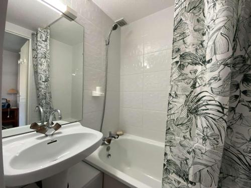 uma casa de banho com um lavatório e uma cortina de chuveiro em Maison Gruissan, 1 pièce, 4 personnes - FR-1-229-54 em Gruissan