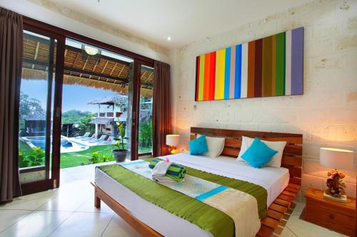 a bedroom with a bed with a colorful painting on the wall at Hill Dance Bali American Hotel in Jimbaran