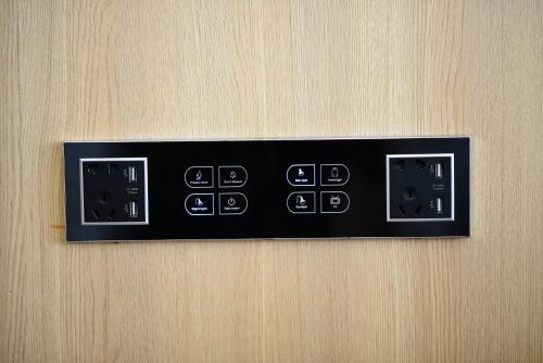 a black control panel on a wooden door at Grand BS Airport Hotel Suvarnabhumi in Lat Krabang