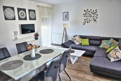 a living room with a table and a couch at Vratovic Apartments in Pula