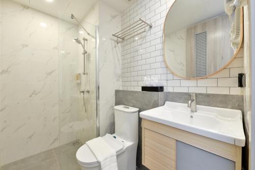 a bathroom with a sink and a toilet and a mirror at Grand BS Airport Hotel Suvarnabhumi in Lat Krabang