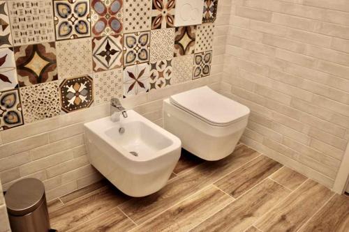 a bathroom with a toilet and a sink at Casa del Tempo Rosa Tassullo OSPITAR in Tassullo