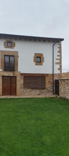 uma casa com um relvado verde em frente em Casa del Medio em Fuentecantos