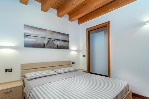 ein Schlafzimmer mit einem Bett und einem Wandgemälde in der Unterkunft New Ride Palmanova Apartment in Palmanova