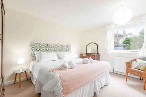 a white bedroom with a large bed and a window at The Cooperage Garden Apartment - 1 bed-1 bath - near harbour in Crail
