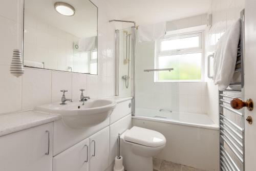 a white bathroom with a sink and a toilet at The Cooperage Garden Apartment - 1 bed-1 bath - near harbour in Crail