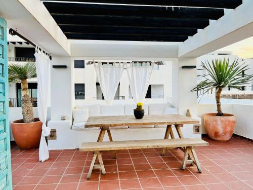 een patio met een houten tafel en een bank bij CalaLuna Mojácar in Mojácar