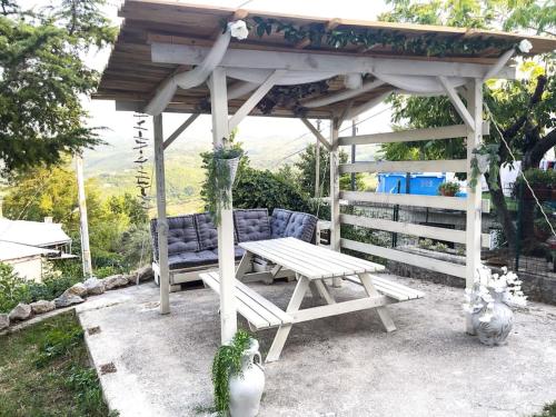 un tavolo da picnic e una panca sotto un gazebo di Biancofino Rooms a San Valentino in Abruzzo Citeriore