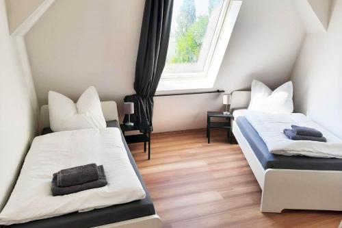 2 Betten in einem kleinen Zimmer mit Fenster in der Unterkunft 2 room fitter flat in Magdeburg