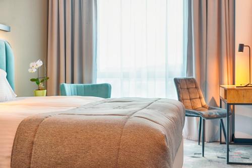 a bedroom with a bed and a desk and a chair at Focus Hotel Premium Bydgoszcz in Bydgoszcz
