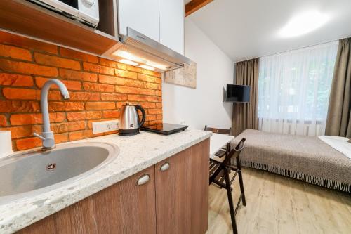 a bathroom with a sink and a bedroom with a bed at Апартаменти MYFREEDOM поруч інститут Шалімова in Kyiv