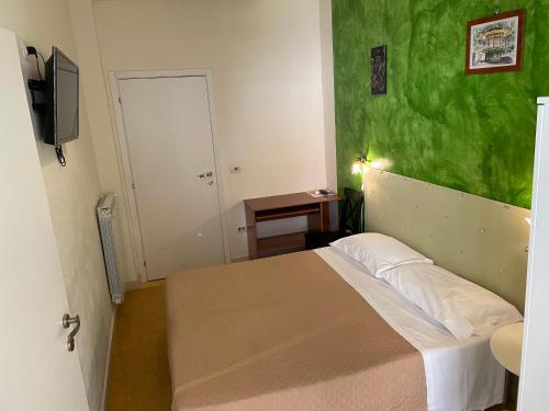 um quarto com uma cama com uma parede verde em Antichi Riverberi in Station em Salerno