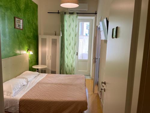 um quarto com uma cama e uma parede verde em Antichi Riverberi in Station em Salerno