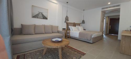 a living room with a couch and a bed and a table at Napa Mermaid Hotel & Suites in Ayia Napa